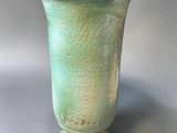 un vase vert posé sur une table