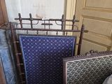 un lit recouvert d'une couverture bleue, avec une chaise à côté