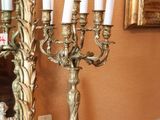 un candélabre en or orné de bougies blanches, avec un miroir en arrière-plan