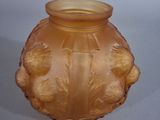 a yellow vase with a design on it sitting on a table