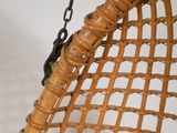 a wicker hanging chair with a chain hanging from it