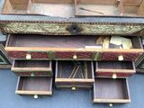 a wooden box with drawers and a clock inside of it