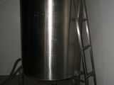 a large metal pot sitting on a ladder in the corner of a room
