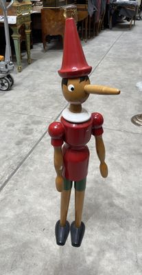 wooden figurine of a man with a pipe sticking out of his nose