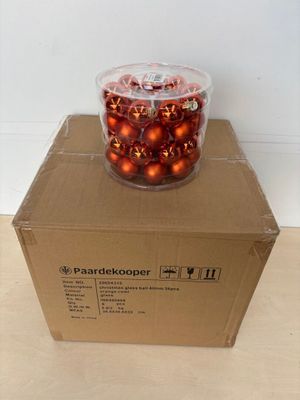 une boîte remplie de décorations de Noël posée par terre