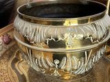 a gold bowl sitting on top of a plate on a table