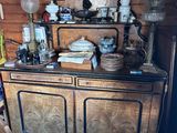 une grande armoire en bois sur laquelle sont posés de nombreux objets