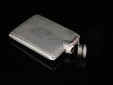 a silver flaskt sitting on top of a black table