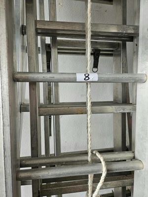 une échelle à laquelle est suspendue une corde, dans une pièce