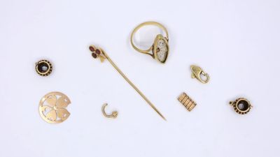 a lot of gold jewelry on a white surface