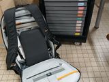 a suitcase and a backpack on the floor next to a stack of boxes