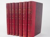 six livres rouges alignés sur une surface blanche