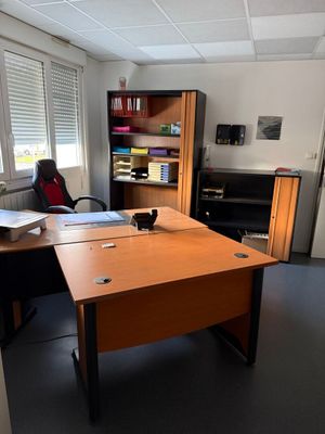 un bureau avec une chaise et une étagère dans le coin