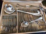 de nombreuses cuillères, rangées dans une boîte posée sur la table