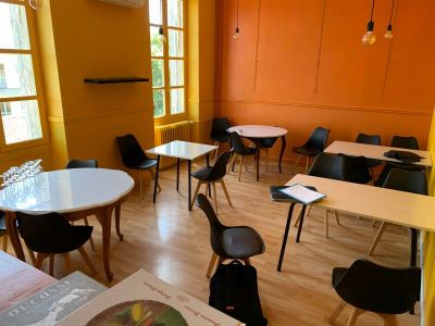 de nombreuses tables et chaises dans une pièce aux murs orange