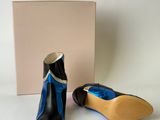 pair of black and blue shoes next to a box with a blue ribbon