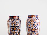 two vases sitting side by side on a white surface