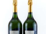 two bottles of champagne on a white surface with a white background
