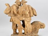 carved wooden sculpture of a man and a woman with a dog
