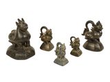 three bronze figurines of animals and a bird on a white background