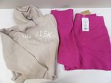 two pairs of pink pants and a pink sweatshirt are on a white table