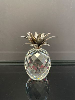 un ananas en cristal posé sur une table en verre