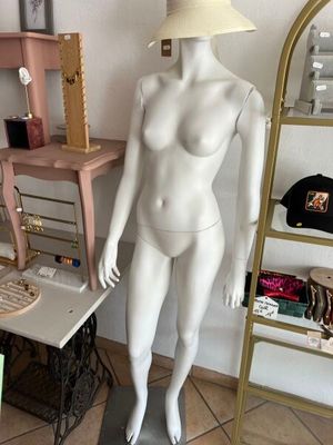a mannequin with a hat on a stand in a room