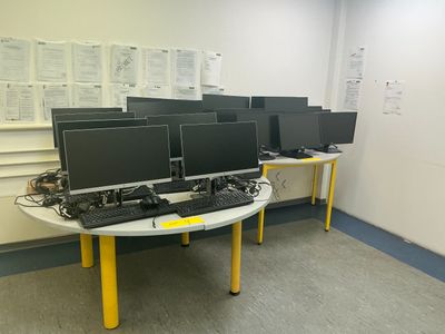 many computer screens on the table in the room