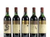 quatre bouteilles de vin sont alignées sur une surface blanche