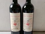 two bottles of red wine sitting next to each other
