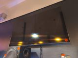 un téléviseur à écran plat fixé au mur au-dessus des haut-parleurs