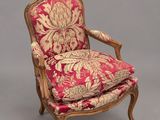 une chaise rouge et dorée dont l'assise est recouverte d'un tissu à motifs floraux