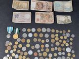 an assortment of coins and medals are displayed on a table