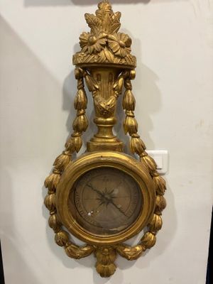 a gold clock hanging on the wall next to a wall clock