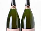 two bottles of champagne on a white table with a white background