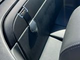 l'intérieur d'une voiture dont la portière est ouverte et où se trouve un sac noir sur le siège passager