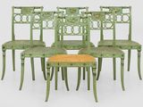 six green painted chairs and a stool with a yellow seat