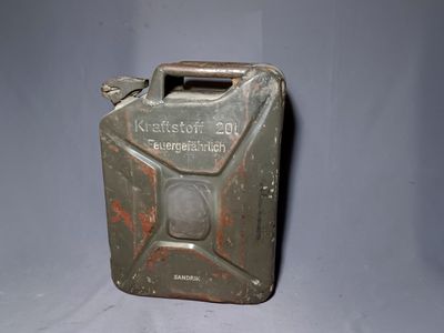 an old metal canister with a metal handle on a gray background