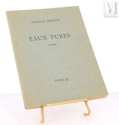 an old book sitting on top of a metal stand on a white surface