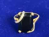 a close up of a black stone ring on a blue surface