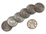 a close up of a bunch of coins next to a penny