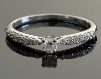 a close up of a diamond ring on a black surface