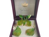 une paire de boucles d'oreilles vertes et dorées dans un coffret violet