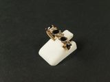 un gros plan d'une bague ornée de pierres noires sur un fond noir