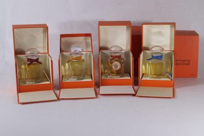 four small orange boxes with perfume bottles in them on a white surface