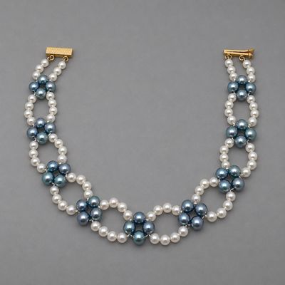 un collier de perles à trois rangs muni d'un fermoir en or
