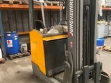 a forklift in a warehouse with pallets in the background