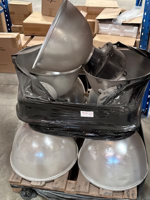 une pile de bols et de casseroles posée sur une palette dans un entrepôt