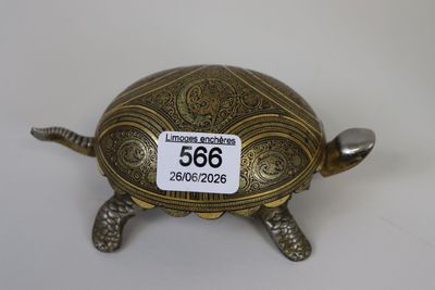 une figurine antique en laiton représentant une tortue, avec une étiquette de prix sur le dos