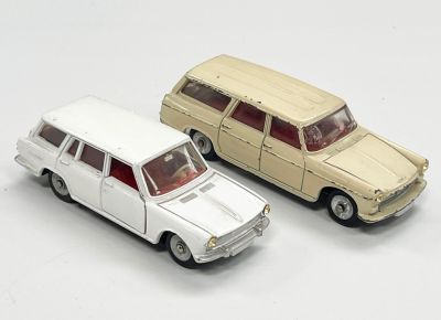 deux voitures jouets assises l'une à côté de l'autre sur une surface blanche
